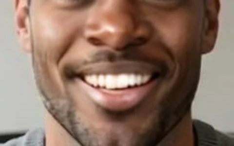 Close-up of a live face swap frame: a convincing smile with slightly smooth skin and the original's stubble on the jaw