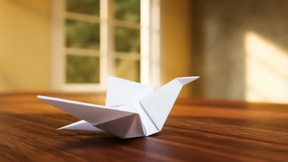 A white paper origami crane unfolds its wings on a desk and flies off toward a sunny window