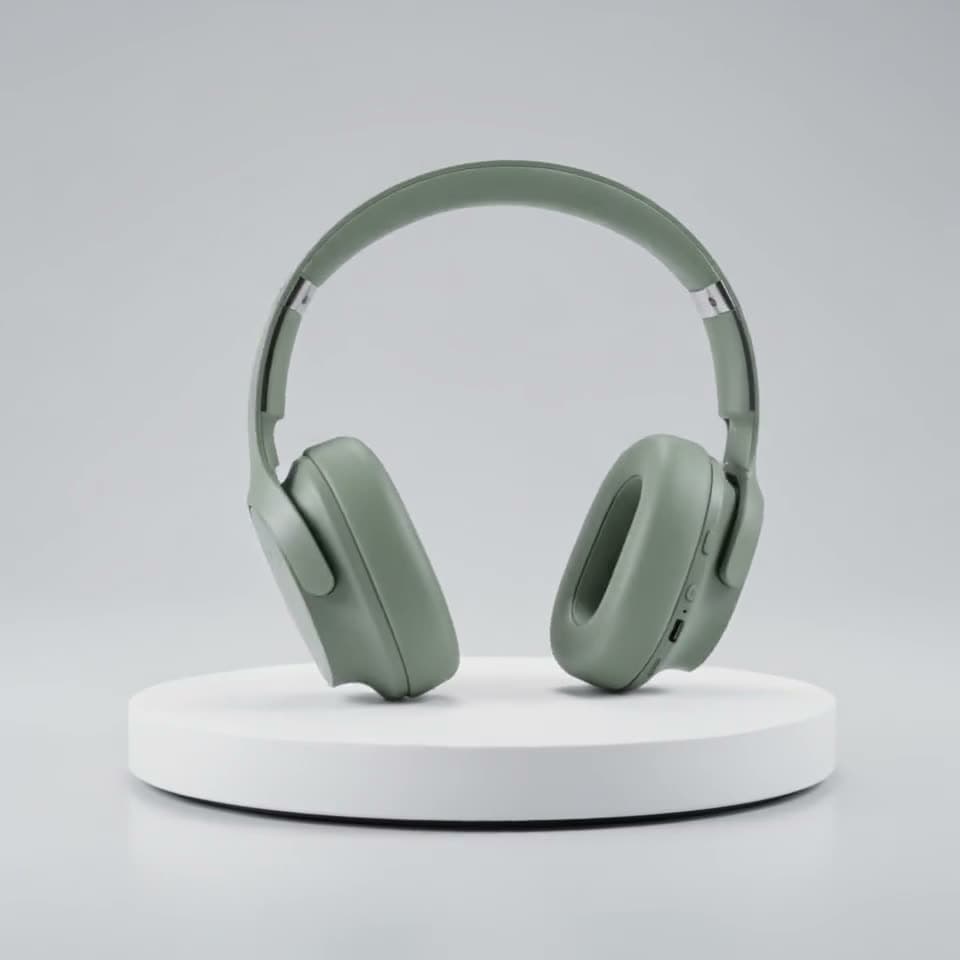 Sage-green headphones turning a full circle on a white turntable