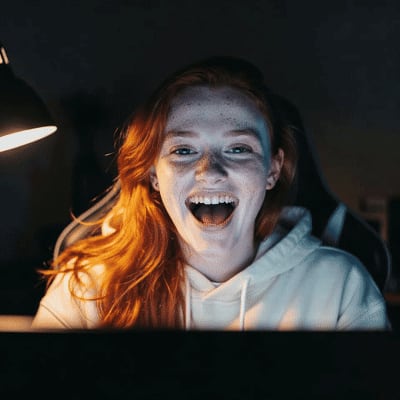Reaction GIF of a red-haired woman laughing at her desk, before the face swap