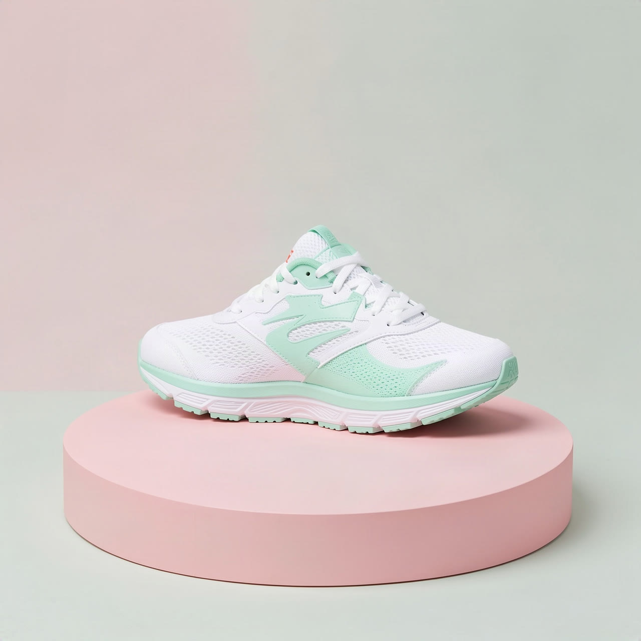 A white and mint sneaker on a pink podium